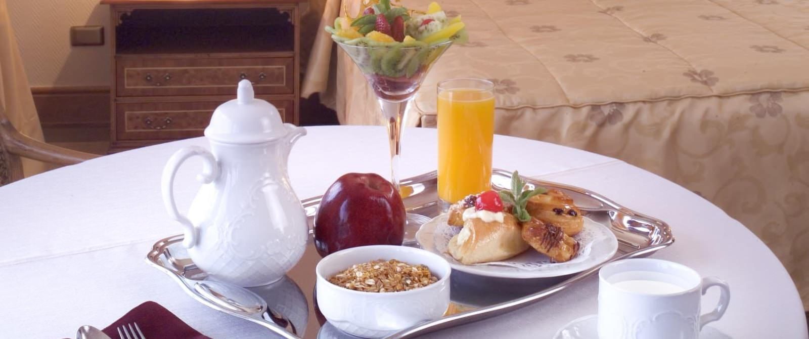 Silver tray with breakfast items on table with white tablecloth