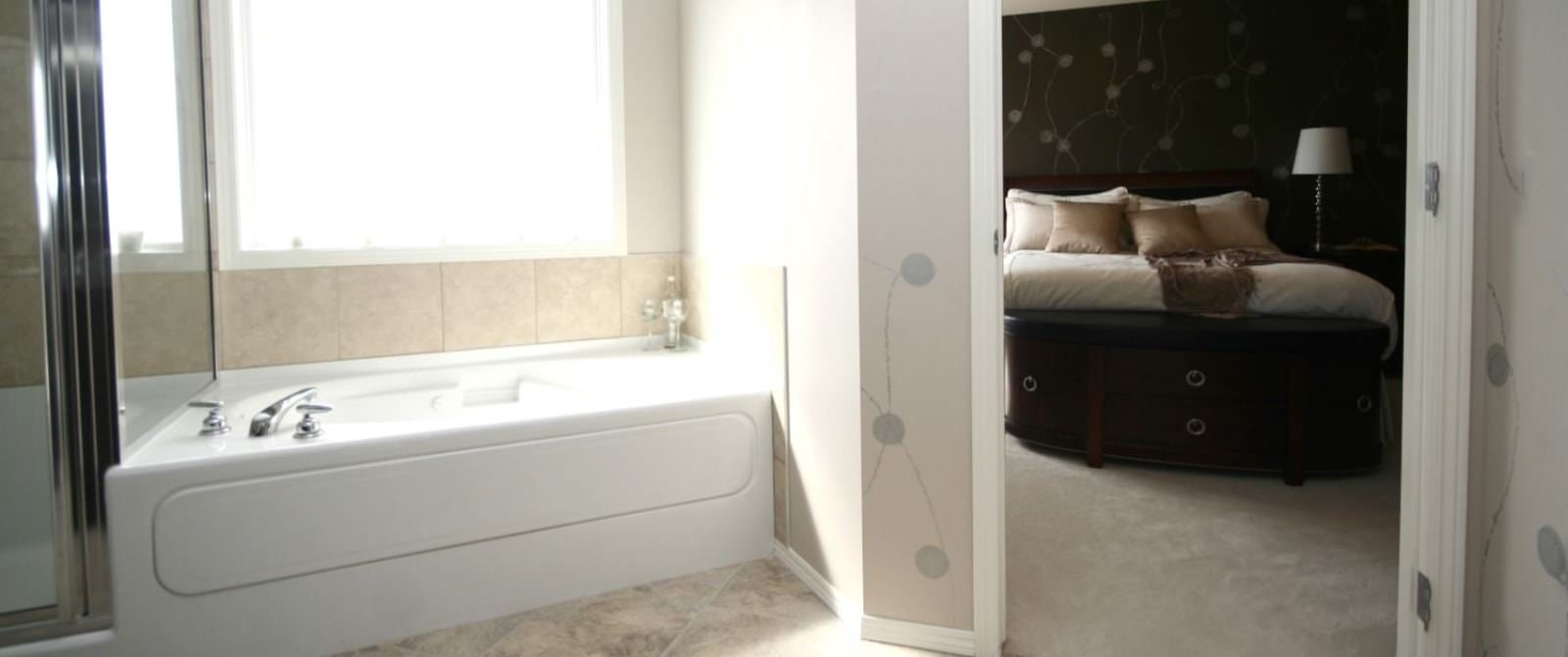 Bathroom with large white tub and separate stand up shower with tiled floor